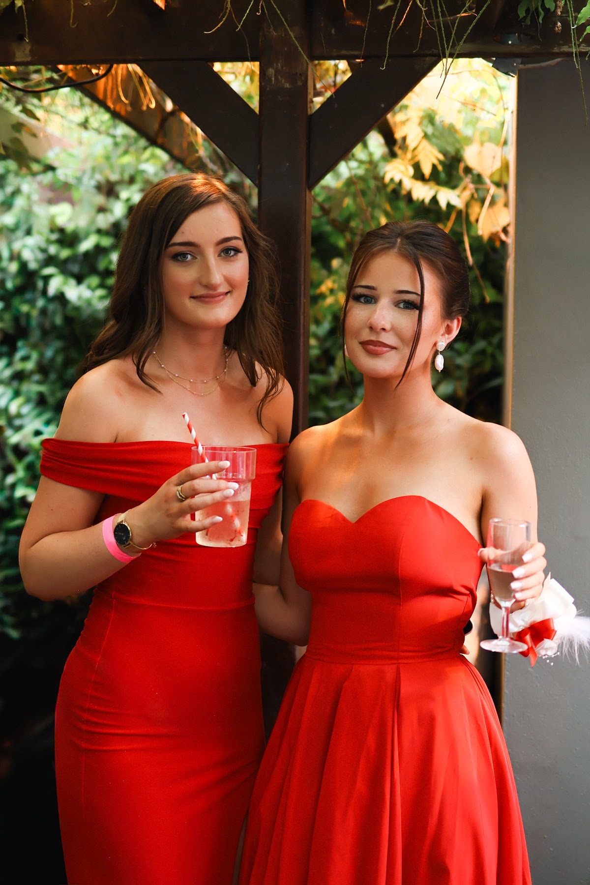Two friends in red dresses posing together